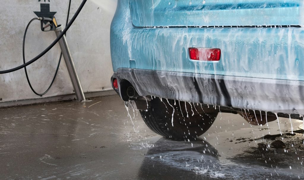 Manual car wash with pressurized water in car wash outside. Summer Car Washing. Cleaning Car Use
